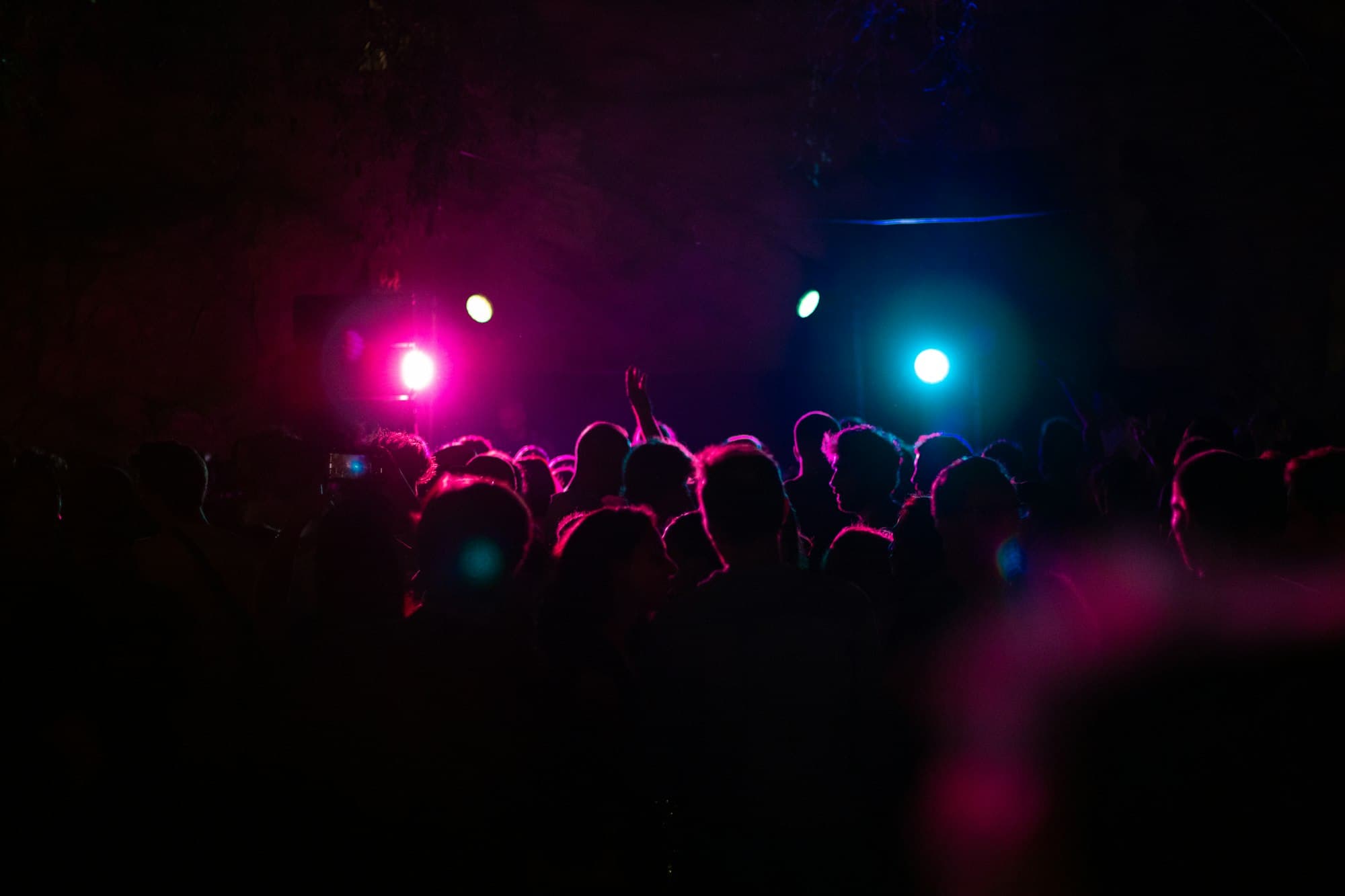 Multidão na pista sob luzes ultravioleta e fumaça